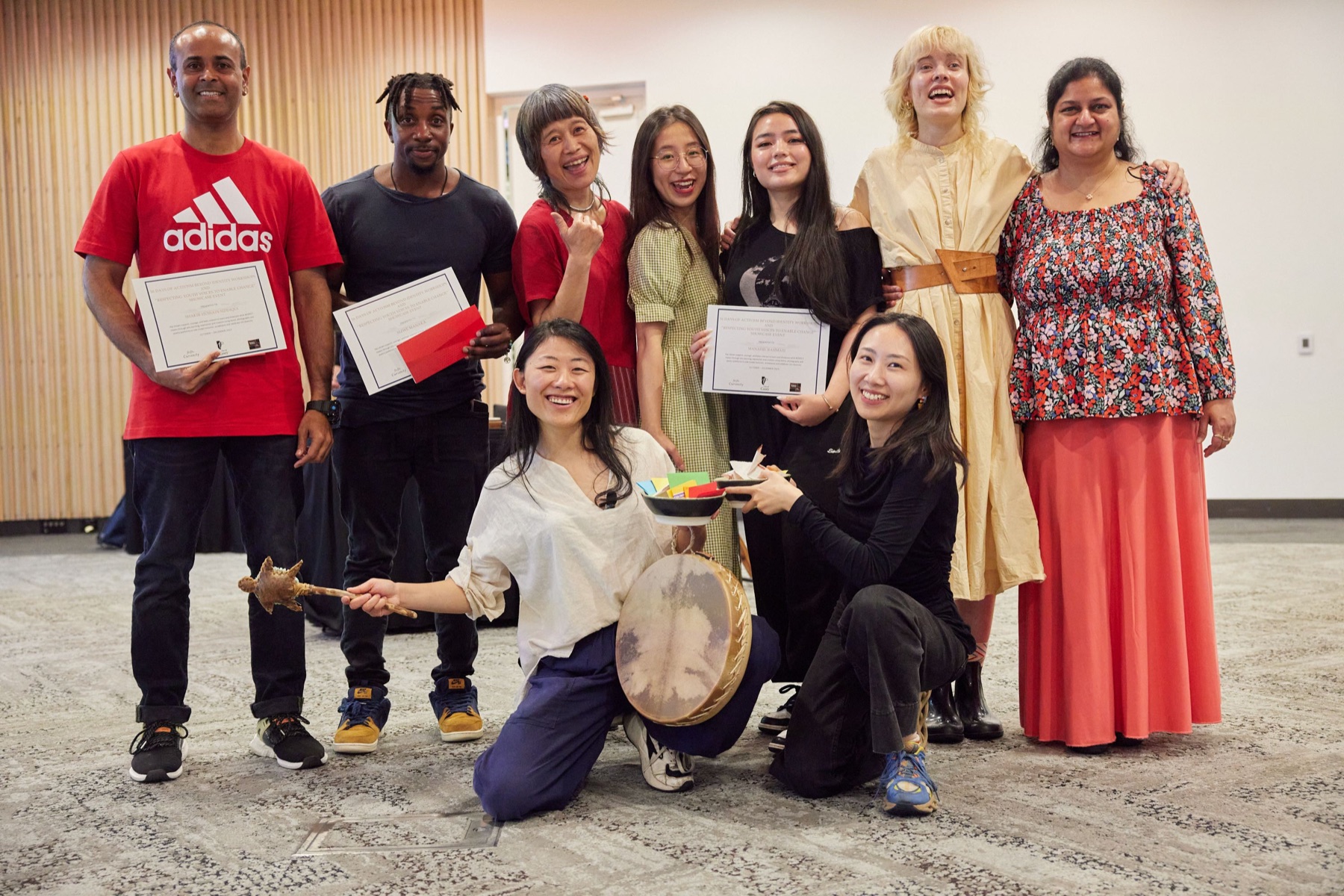 Volunteers and artists holding certificates